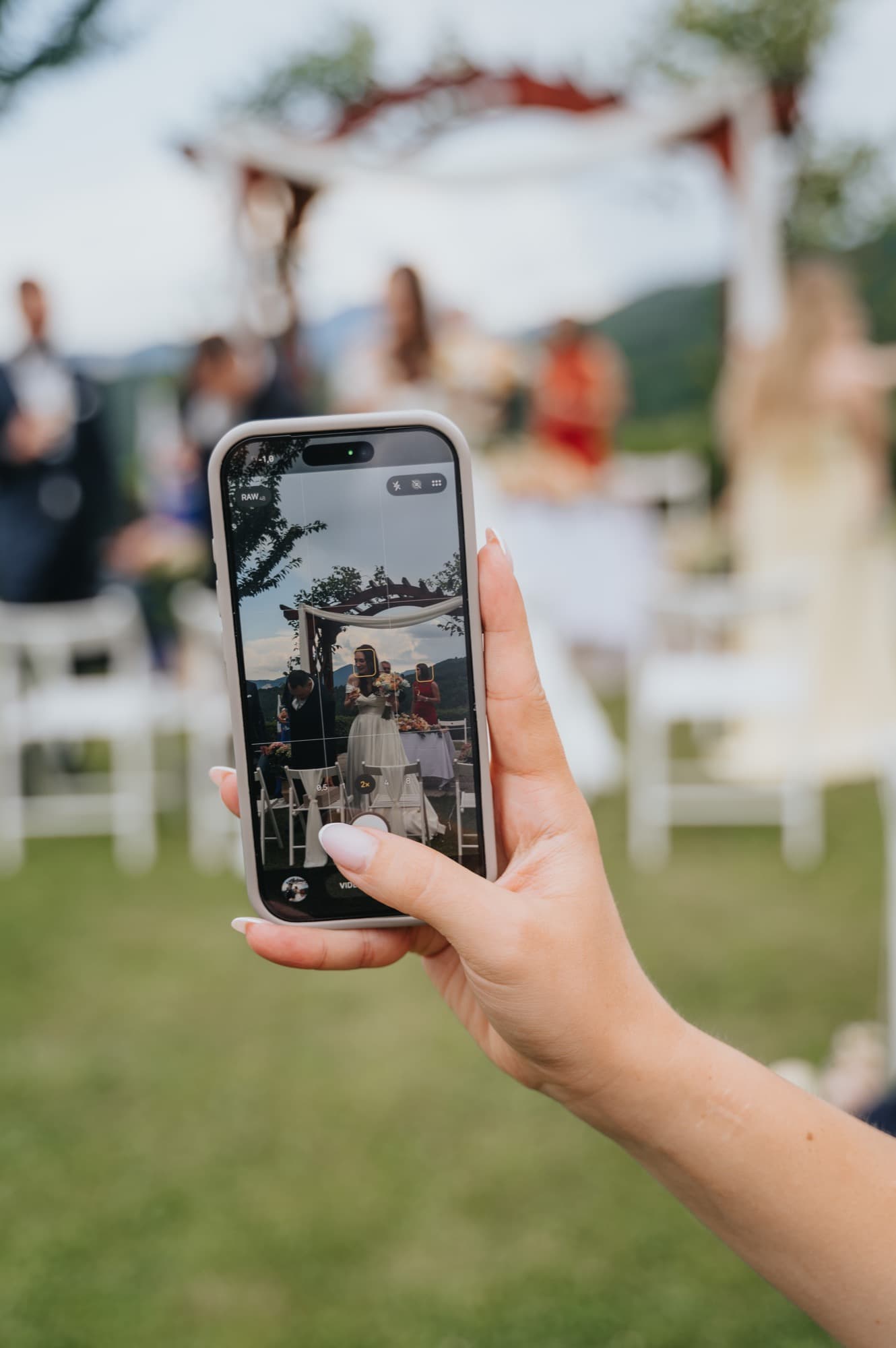 Gost s telefonom fotografira poročni obred