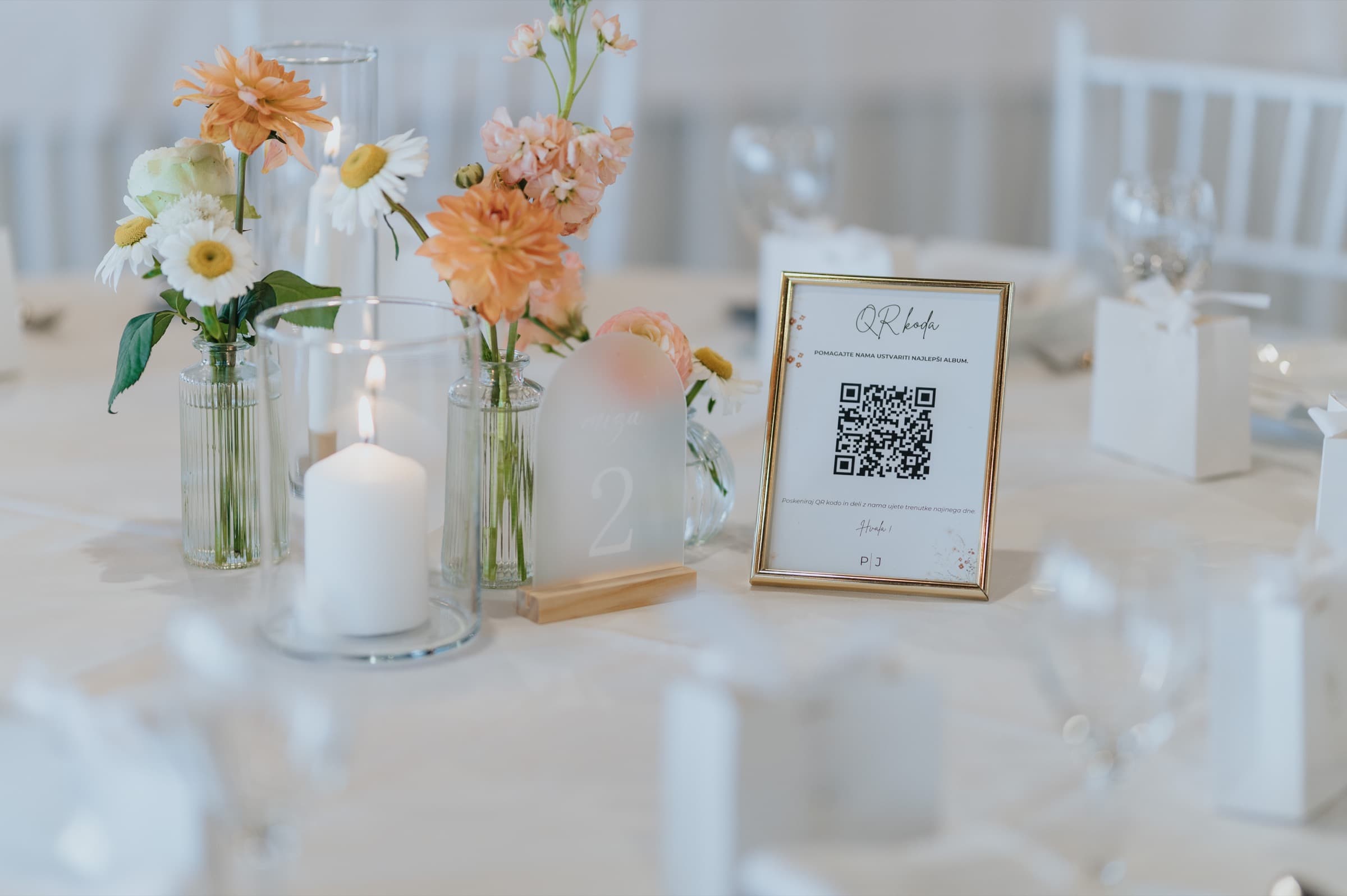 Primer postavitve QR kartice na poročni mizi z rožami in svečami